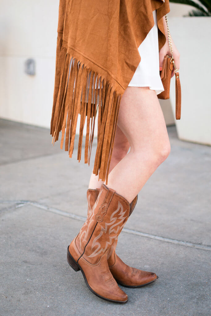 Have you ever wondered what to wear to the rodeo, or how to style your cowboy boots? Click through to shop this gorgeous tan suede vest perfect for rodeo and football season!
